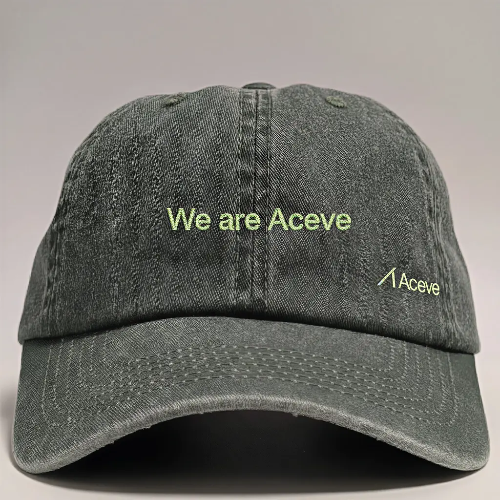M&ouml;rkgr&aring; keps med "We are Aceve" broderat i ljusgr&ouml;nt.